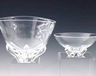 Two mid 20th century Steuben Crystal bowls designed by Donald Pollard.  Includes a shape #8101 "Peony" center bowl, and a shape #8059 "Floret" bowl.  Both with etched "Steuben" signatures at underside.  Minor wear.  Up to 10" long and 7 1/2" high.