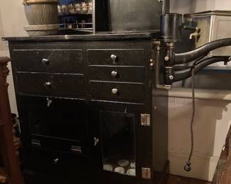 Antique metal podiatrist cabinet with many milk glass and glass containers remaining