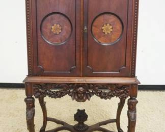 1170A	OUTSTANDING WALNUT CARVED 2 DOOR CABINET, DOORS HAS 2 ROUND INLAID PANELS, INTERIOR W/3 SHELVES & ONE DRAWER, BASE HAS CARVING OF WOMAN BUST ON ALL FOUR LEGS ALONG W/A CHERUB & FLOWER BASKET AT CENTER OF STRETCHER & PIERCED CARVING, APPROXIMATELY 35 IN X 20 IN X 63 IN HIGH
