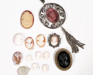 CAMEO COLLECTION | Loose cameos and cameo jewelry, including a jet cameo in a gold-tone pin, a cameo in a marcasite pin, a purple glass intaglio cameo pendant, a shell carved cameo with two figures night and day (1.75 in.), and 10 loose cameos and others. 
