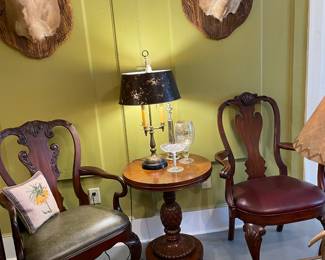 Two leather seated mahogany armchairs with Ethan Allan pineapple mahogany table and stag heads