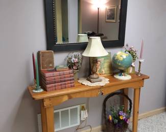 Basement entry/sofa table.  The red cover WWII books are priced as a set.  The green candle holder is Wedgewood Jasperware.  The globe is a piece of a vintage air race magnetic plane  game by Replogle.