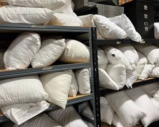 Bed pillows piled up on shelves everywhere for sale! We cannot answer pricing questions as usual. 
 So sorry!