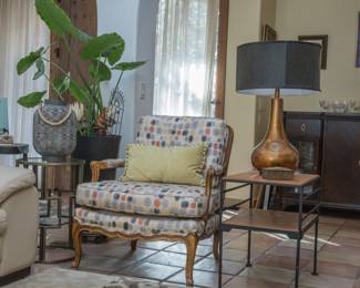 left to right:  Beautiful French upholstered arm chair.  Perfect for your sitting room:  $280.00.  MCM metal and wood side table (22.5"h x 16"w x 24"d):  $98.00.  Bronze/gold glaze table lamp with cloth lamp shade and finial:  $140.00