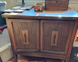 Sewing cabinet with flip top table, hidden machine storage.