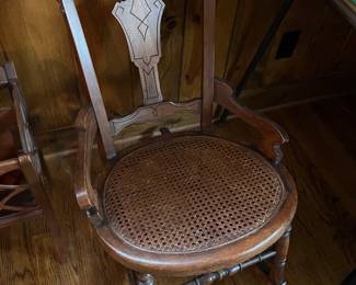 Vintage carved wood rocking chair with cane seat.