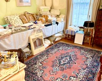 A room filled with beautiful new and vintage linens and furniture.