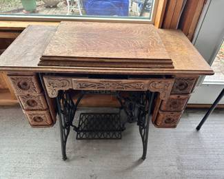 Old Singer sewing machine in cabinet.