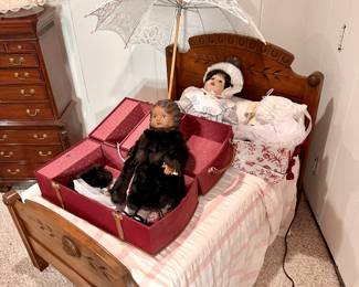 Antique Victorian child's bed, and two of the several dolls.