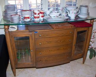 Wooden cabinet with glass top and holiday dinnerware