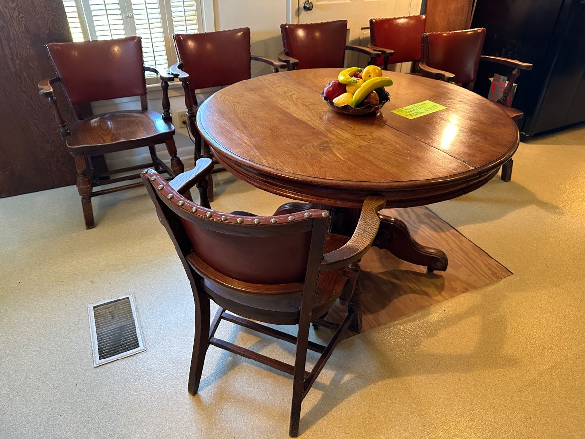 This beautiful round pedestal oak table was set up with its leaf at the sale, but this is without the leaf! Also have 8 oak and leather club chairs available.