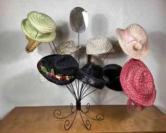 BIHY104 Vintage Cellophane Staw Hat Assortment	A collection of vintage cellophane straw hats and a hat display rack. The hats range in size, shape, and color, and were made by various manufacturers, such as Frederick & Nelson, Noreen Fashion, Beresford, The Paris Boutique. The mirror on the hat rack has a minor chip. Display bust not included.
