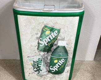 BIHY102 Sprite Ice Cooler Advertisement	This is a green and white ice cooler advertising Sprite lemon-lime soda pop. This beverage cooler comes on wheels, and has a clear lid so you can easily see the products inside. The lid is chipped right near the handle and some plastic brackets on the corner are broken.&nbsp;
