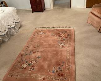 Plush pale pink area rug with white tassel ends