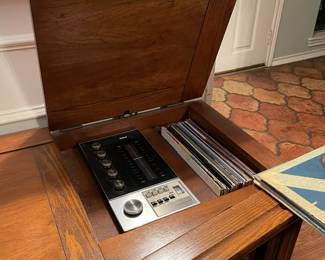 Circa 1960's phonograph and receiver cabinet. Turntable and radio along with collectable vinyl records. Statement piece and rare find! 