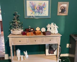 White washed console table with three drawers and bottom shelf