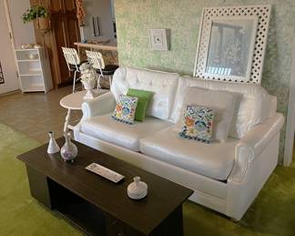 This white sofa seems to match the style of the white living room chair (previous photo).  The coffee table is also in good shape.