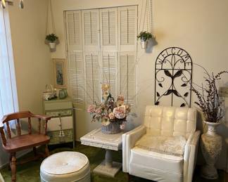 A couple of chairs, an ottoman, and a side table are the primary items in this photo.