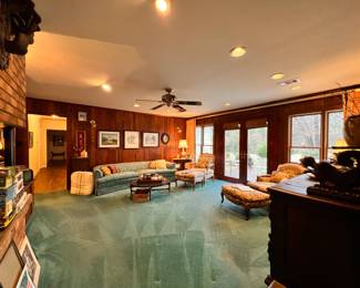 Family Room | An inviting vintage silk damask upholstered sofa, two vintage Louis XV Bergere chairs with matching ottomans, a pair of cut crystal lamps (possibly Waterford), a period Midcentury coffee table, an extensive collection of mystery novels, and a stunning 15th century Flemish sideboard are only some of the highlights in this comfortable room.