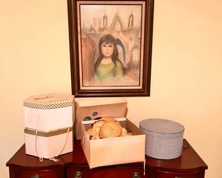 Bedroom 1 | 1940's Mahogany vanity table with brass hardware, vintage hat boxes, and a beautiful painting of a young girl in front of a Gothic church.