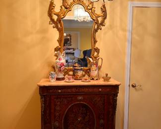 Entrance Hall | A beautiful inlaid French cabinet with brass appliqué topped with pink marble, numerous lovely antique and vintage fine porcelain wares, and a vintage carved giltwood mirror decorate the entrance hall.