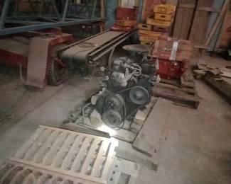 parts of a crane/lift, conveyer belt, old coke crates, engines, backdrop for parade float (?)