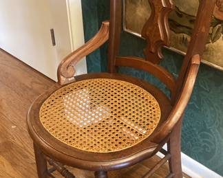 One of two antique cane seat chairs