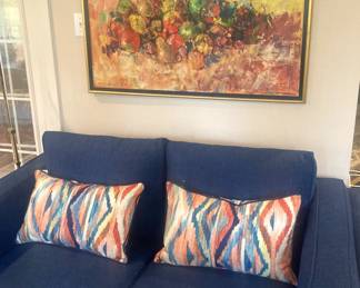 Navy blue loveseat; colorful art and pillows