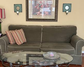 Wonderful sofa, glass top oval metal base oval table, framed art.