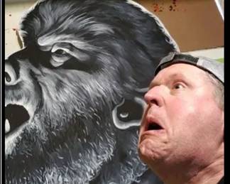 Jeff Parson posing with his Wolf Man painting