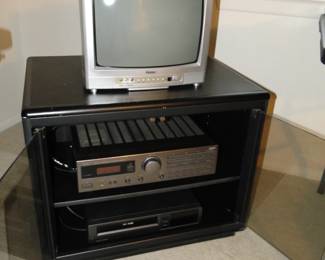 Small variety of electronics, along with a very nice black and glass cabinet
