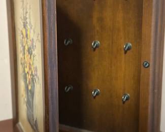 Hidden inside this lovely wooden framed picture is a key rack holding up to a dozen sets of keys! 