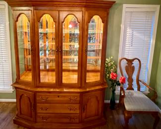 A spectacular oak cabinet with glass shelves and lighting by the Sumter Cabinet Co.