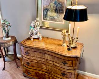 Bombe chest in formal living room, brass lamp, plant stand 