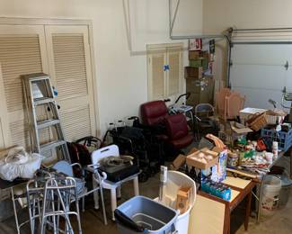 Garage with lots of medical aids, wheel chairs, walkers, potty and shower chairs, ladders, light bulbs