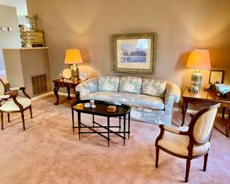 The formal sunken living room. Center coffee table is metal. Brass lamps. Wall art. Oriental porcelains. Floral sofa and loveseat. 