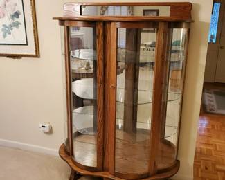 Newer bow-front cabinet with serpentine glass shelves