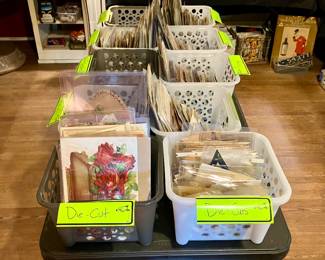 Table full of antique trade-cards, Victorian die-cuts and Victorian scrap, all sorted into categories 