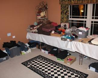 This large room is full of clothing items, towels and linens.