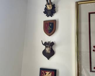 Top to bottom: Coat of arms England 3 lions on red plaque $150, Antique fancy Black Forest deer mount $395, coat of arms "Union" red and blue chevron with cannon $100, small antique Black Forest deer horn mount $175, Coat of arms golden griffin on red field $225.