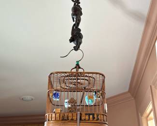 CHINESE BIRDCAGE | Suspended by three carved wood monkeys, the interior with miniature ceramics, and a single crossbar. - l. 8 x w. 8 x h. 14 in (birdcage only)
