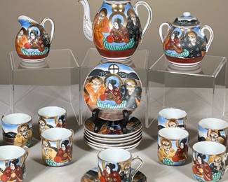 (22PC) JAPANESE TEA SET | Showing 2 men and a woman in colorful outfits with gilt decoration, including; 11 small teacups, 8 saucers, lidded sugar bowl, creamer, and small teapot. - l. 6 x w. 4 x h. 6 in

