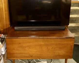 Antique drop-leaf table, flatscreen TV, Polk soundbar, subwoofer and remote