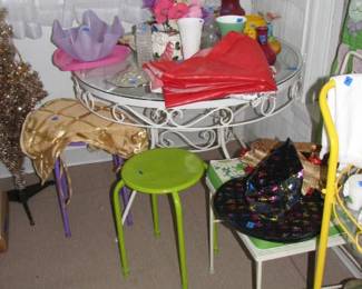 A nice wrought iron round table and one wrought iron chair. Also a couple of colorful stands