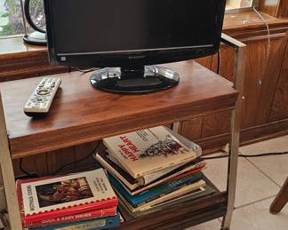 vintage stand and small flatscreen, lots of local cookbooks