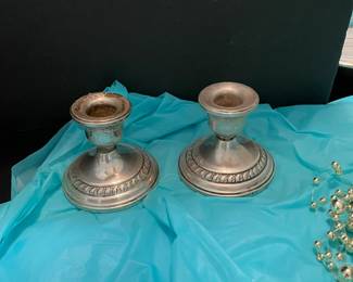 Matching silver candlestick holders with heavy bases.