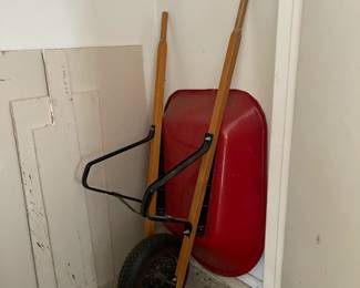 Like new red metal wheelbarrow with single wheel and wooden handles