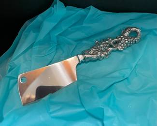 Large cheese knife with grape cluster handle.