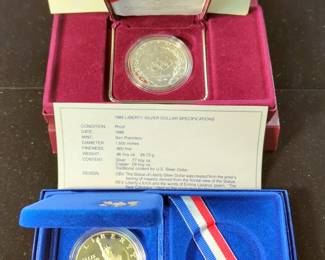 1986 Liberty Silver Dollar And 1988 US Olympic Silver Dollar With COA, Both 90% Silver, Both In Display Cases