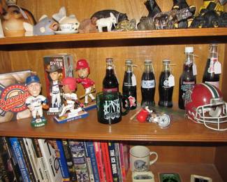 We have an incredible sports memorabilia collection that includes books, bobbleheads, sports banners, commemorative drinks, vintage sports games, & hats.